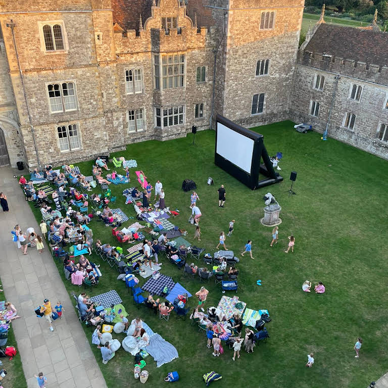 Outdoor cinema event with large LED screen in charming Berkshire courtyard setting.