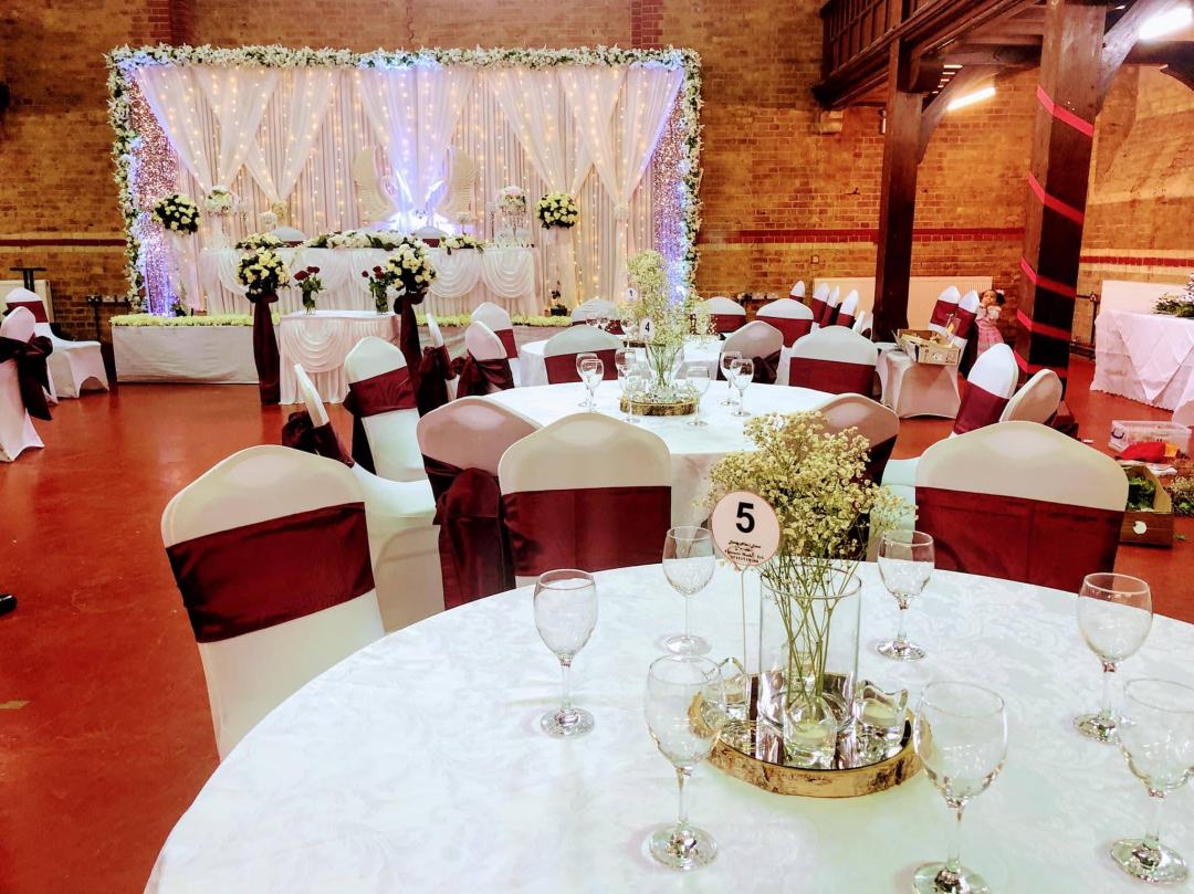 Elegant wedding venue with floral centerpieces and twinkling lights in Wheatsheaf Hall.