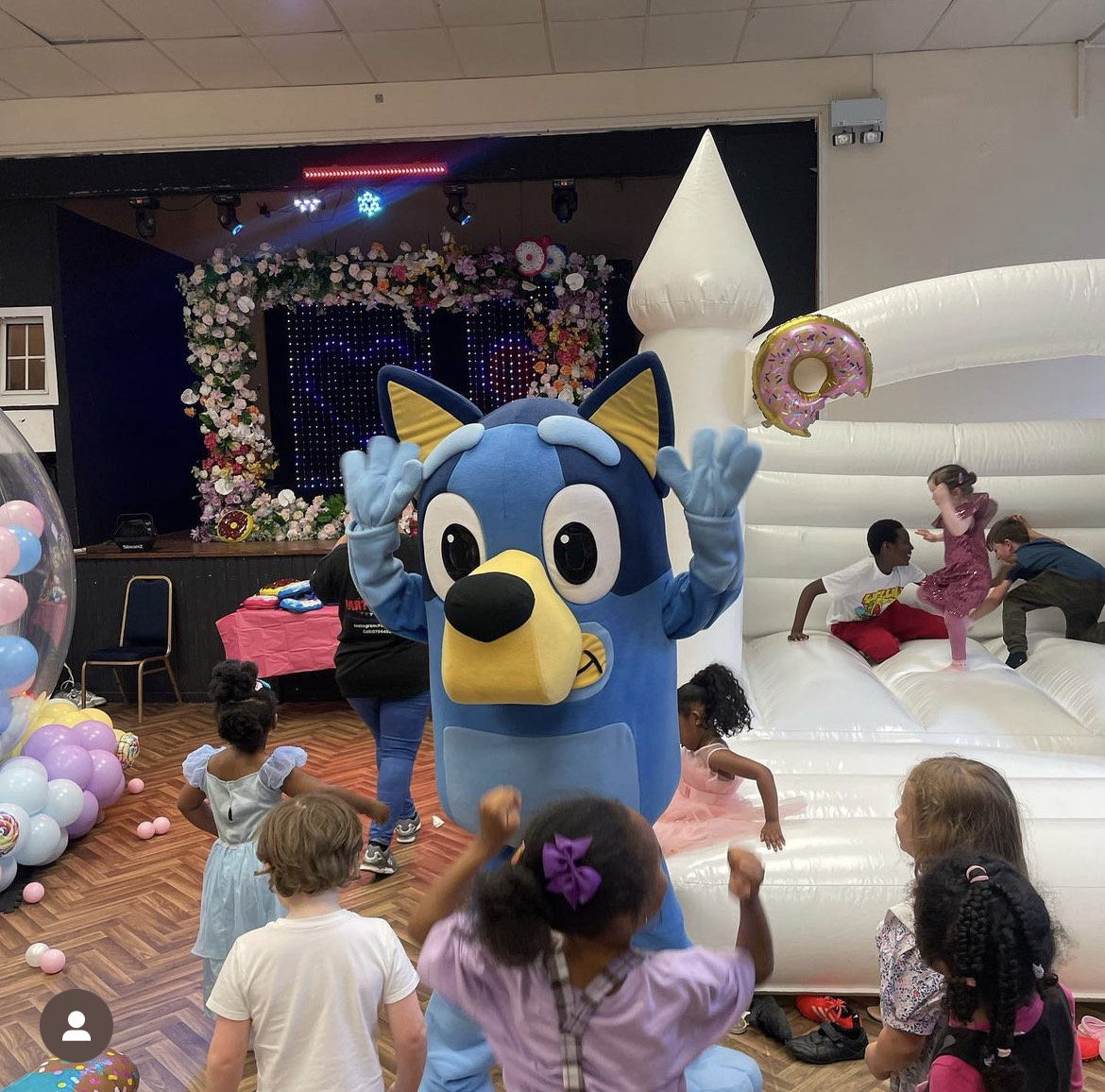 Children's event at Magdalen Hall with costumed character and bouncy castle fun.