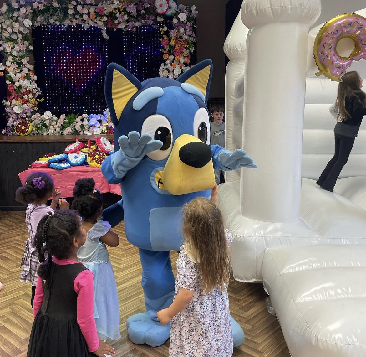 Costumed character at children's party in vibrant Magdalen Hall event space.