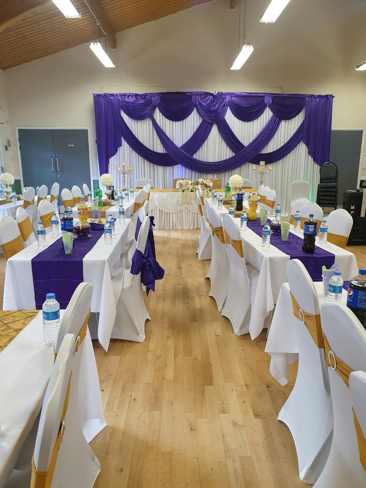 Elegant event space with white tables and purple accents for formal gatherings.