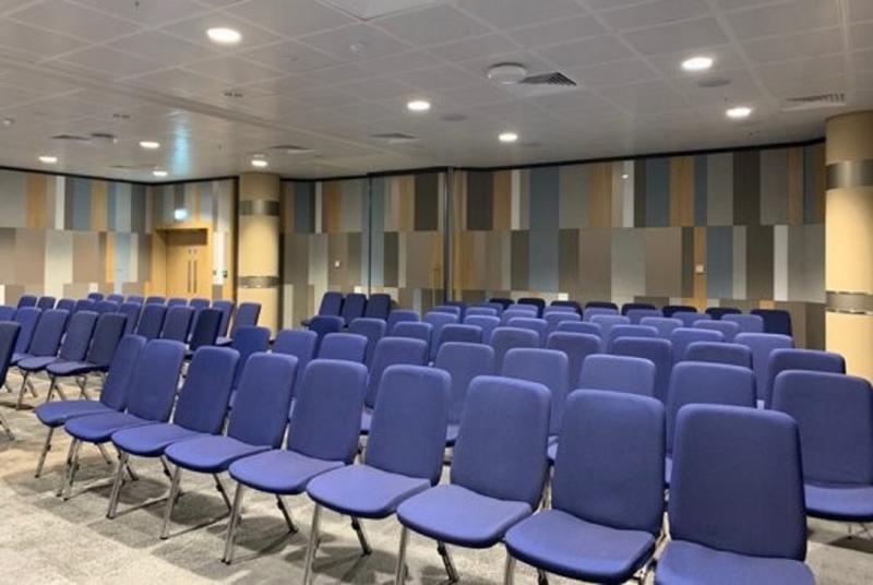 Conference room in ICC Birmingham with blue chairs, ideal for workshops and presentations.