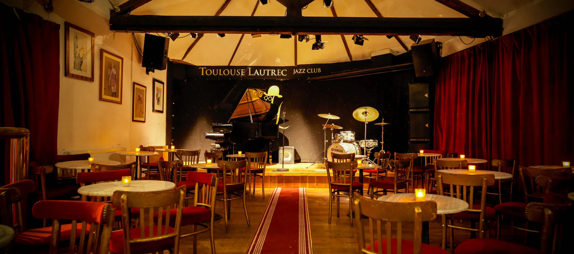 Intimate jazz club in Toulouse Lautrec with warm lighting, perfect for live music events.