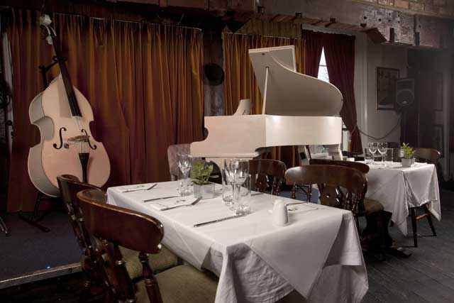 Intimate dining space with grand piano, perfect for private dinners and live music events.