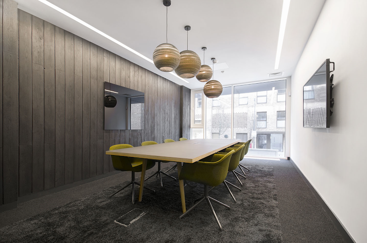 Modern meeting room at Cannon Wharf with wooden wall, ideal for collaboration and client meetings.