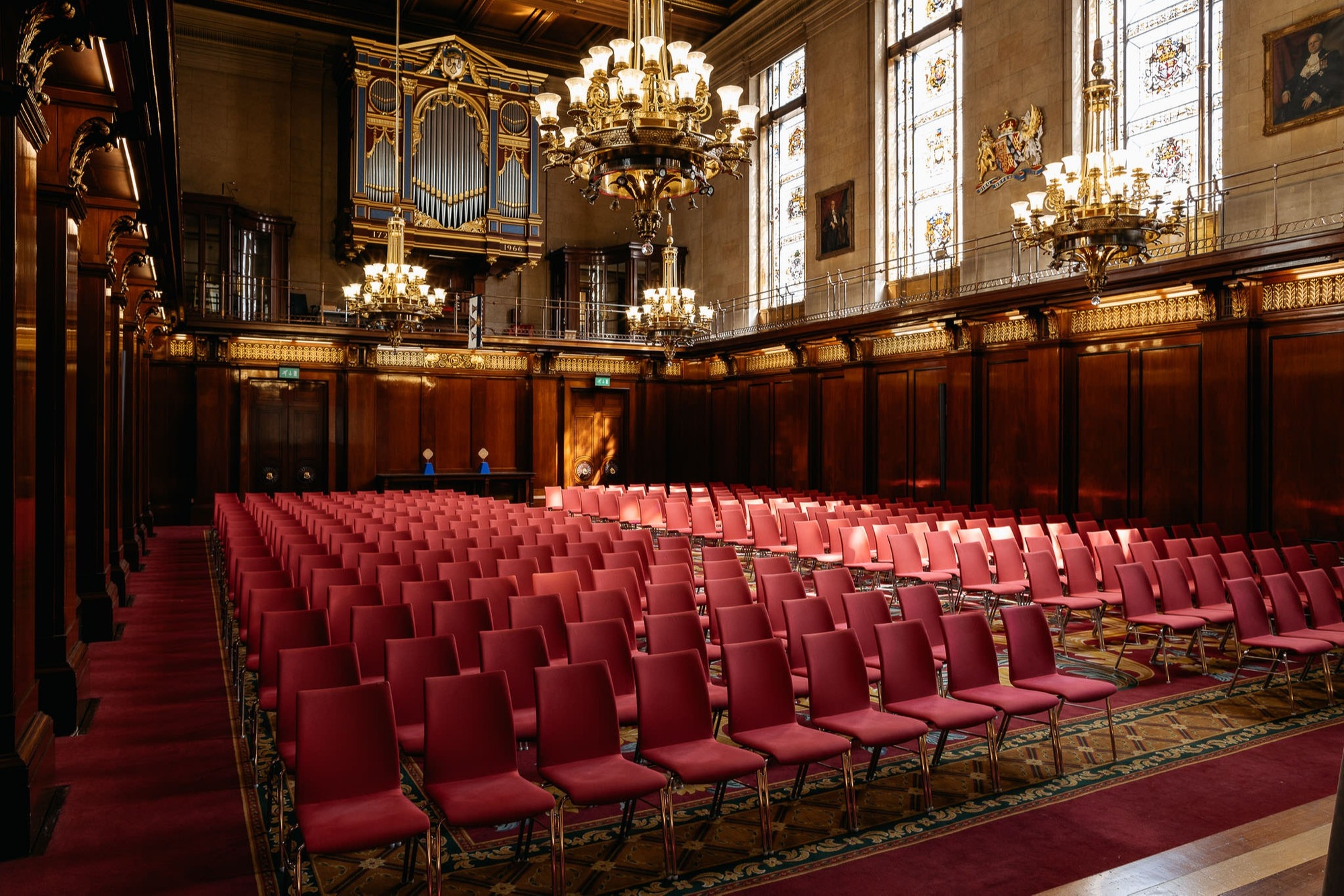 Main Hall in The Venue with red chairs, elegant wood paneling for formal events.