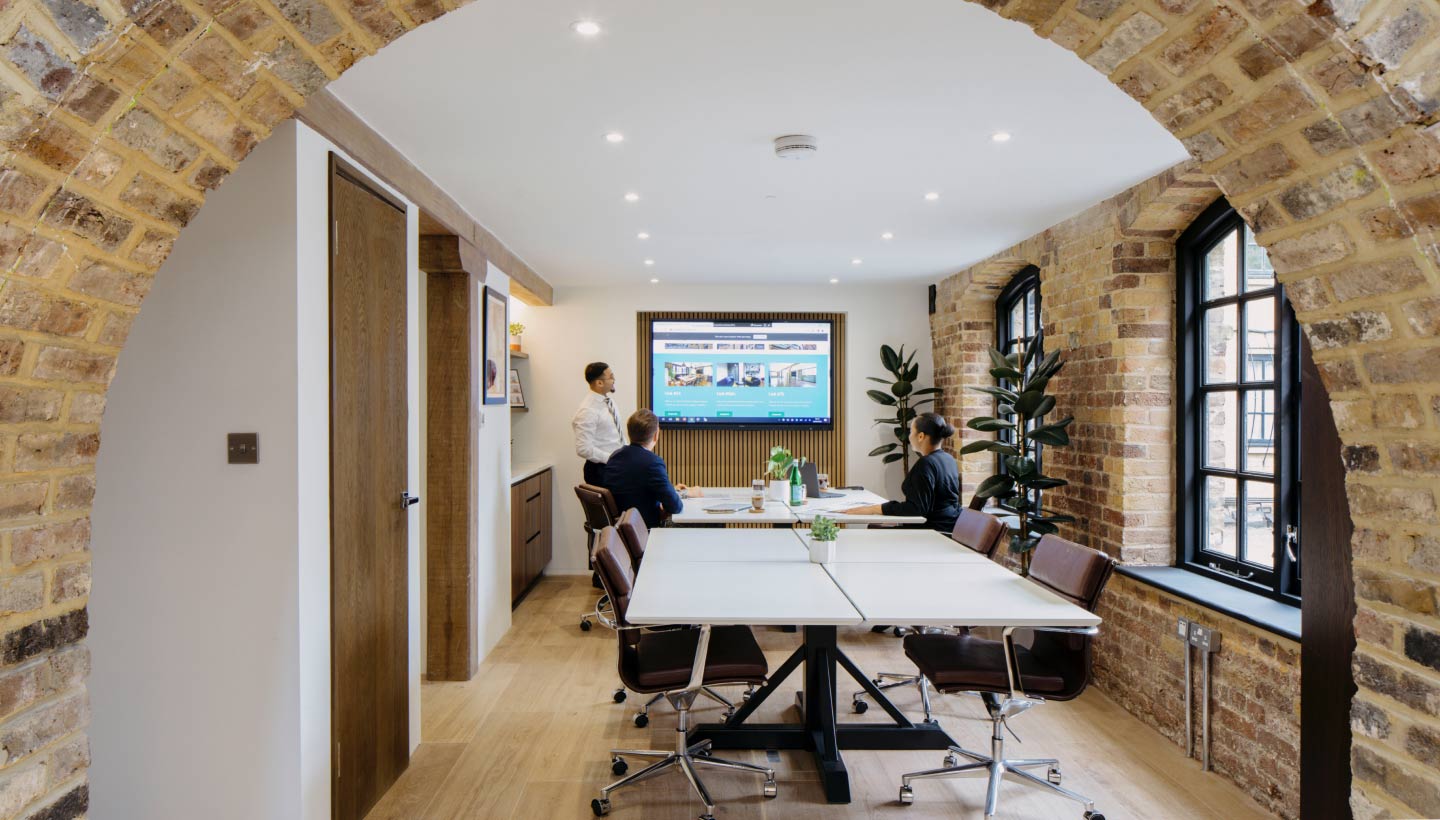 Modern meeting room in GO Bermondsey with large screen, ideal for workshops and strategy sessions.