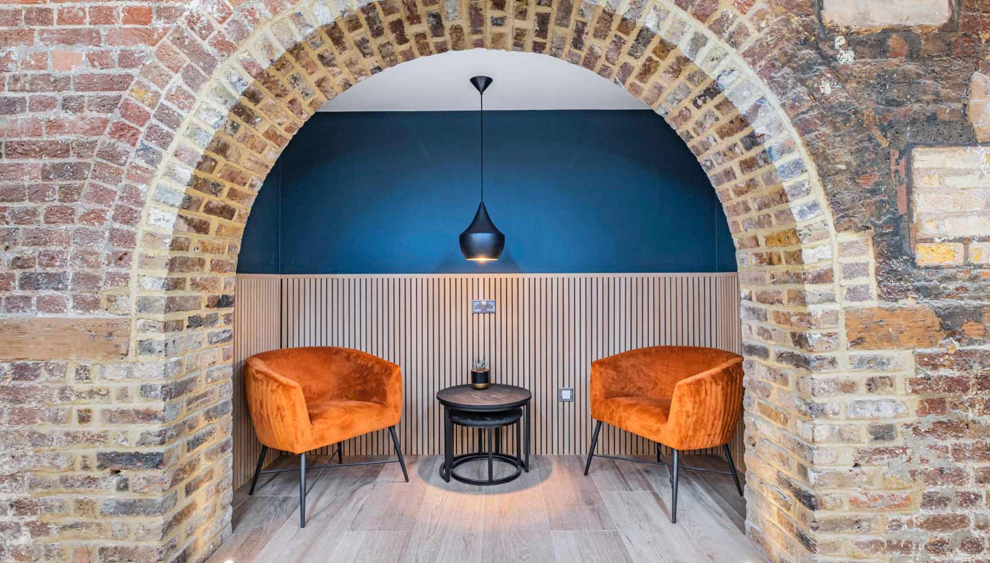 Stylish meeting space with orange chairs in GO Bermondsey for creative discussions.