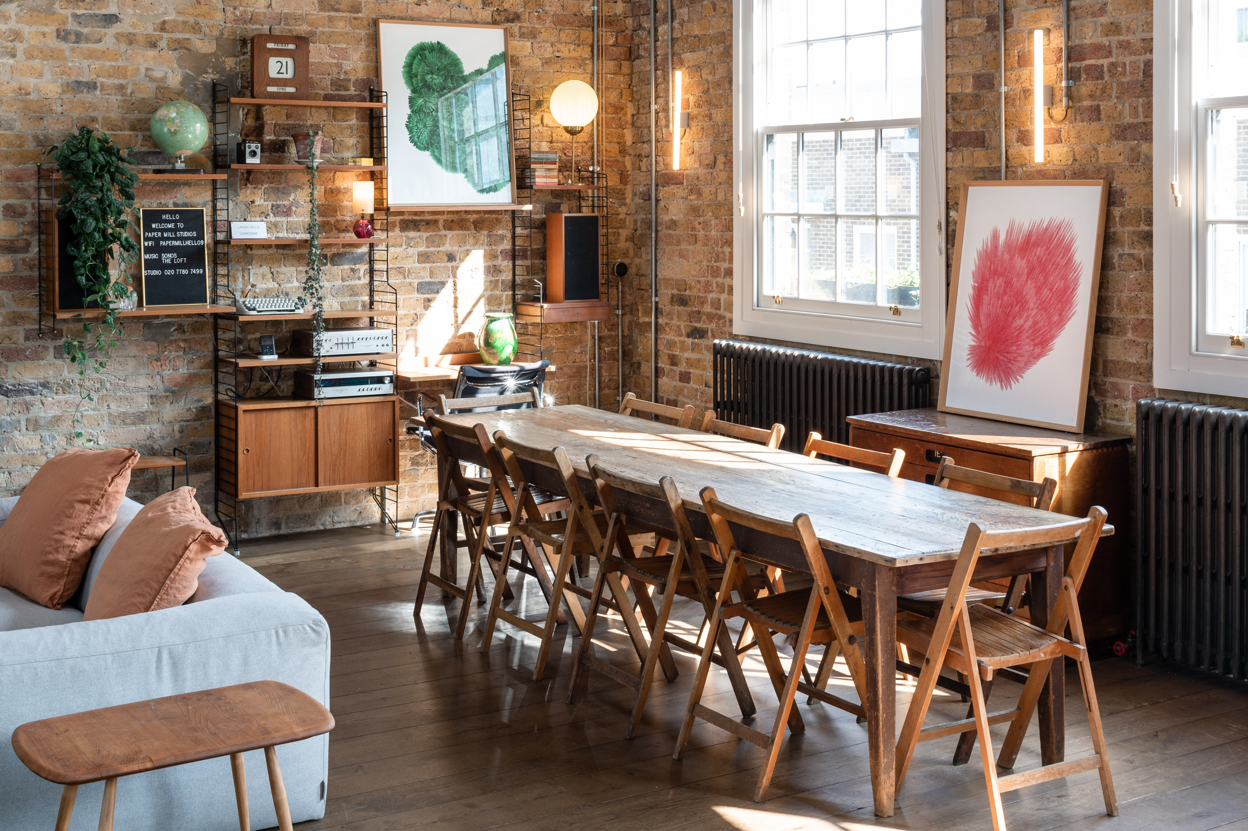 Stylish Loft Studio meeting space with wooden table, perfect for collaboration sessions.