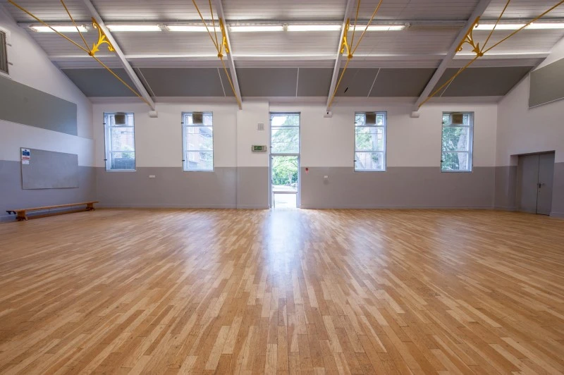 Spacious event hall with polished wooden floors at Evelyn Community Centre for gatherings.