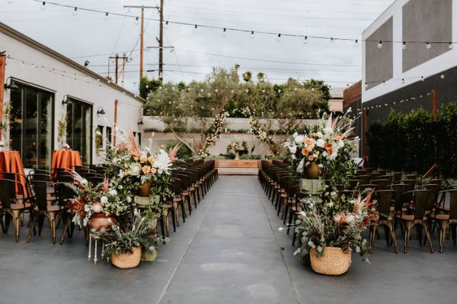 Outdoor wedding venue with floral arrangements and elegant string lights.