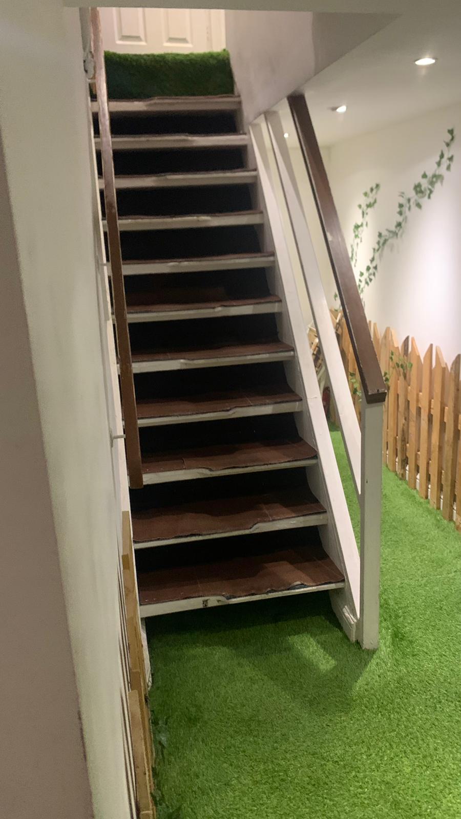 Staircase with wooden railings at Relaks Radio Cafe, ideal for events and meetings.