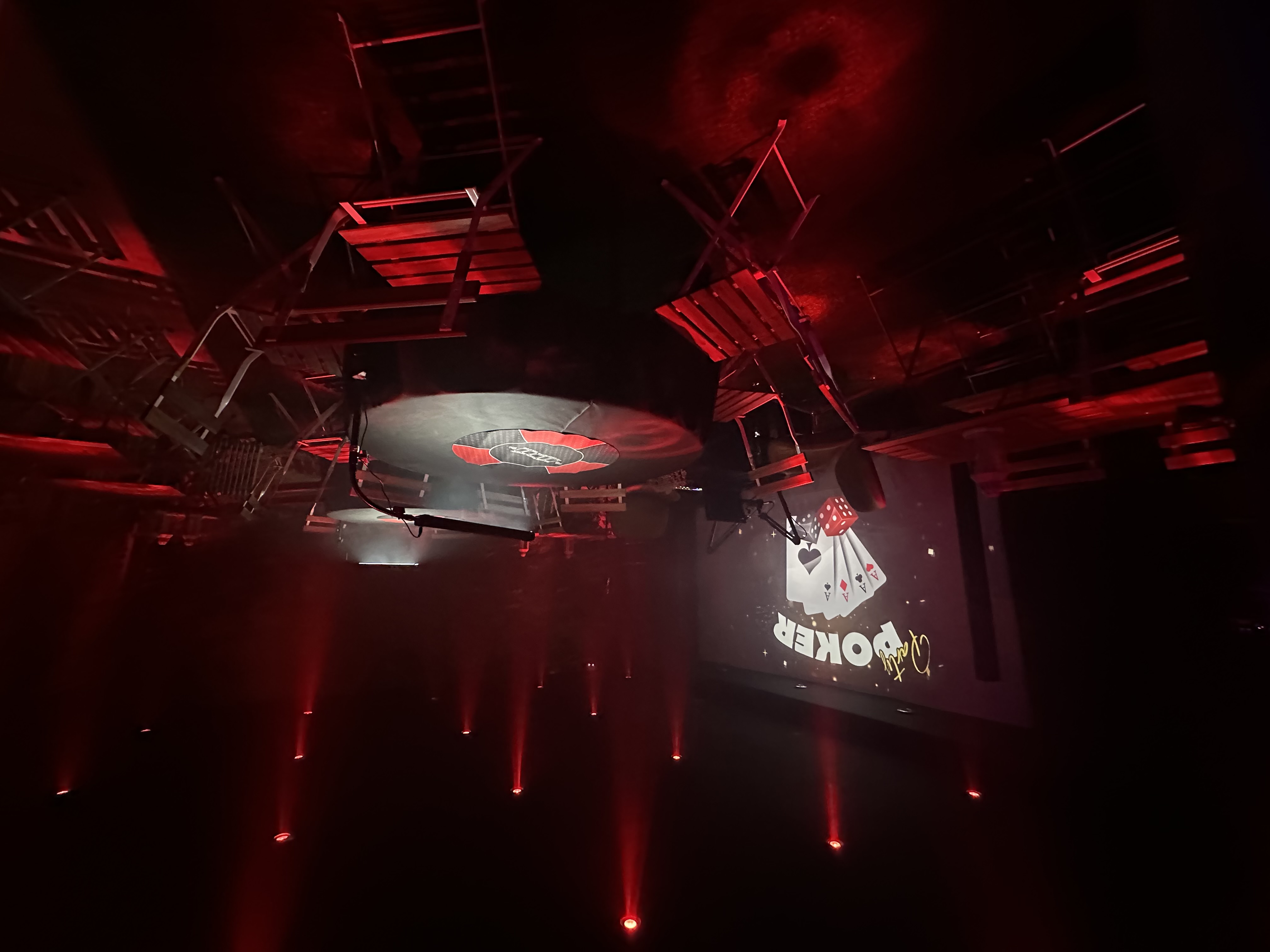Poker-themed event at Relaks radio cafe with a circular stage and ambient red lighting.