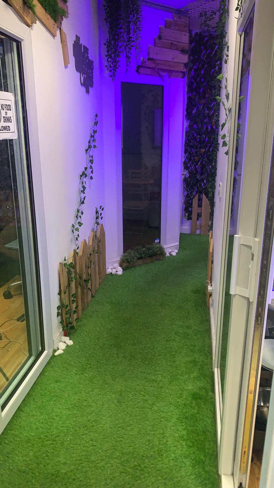 "Relaks radio cafe corridor with artificial grass, ideal for networking events and meetings."