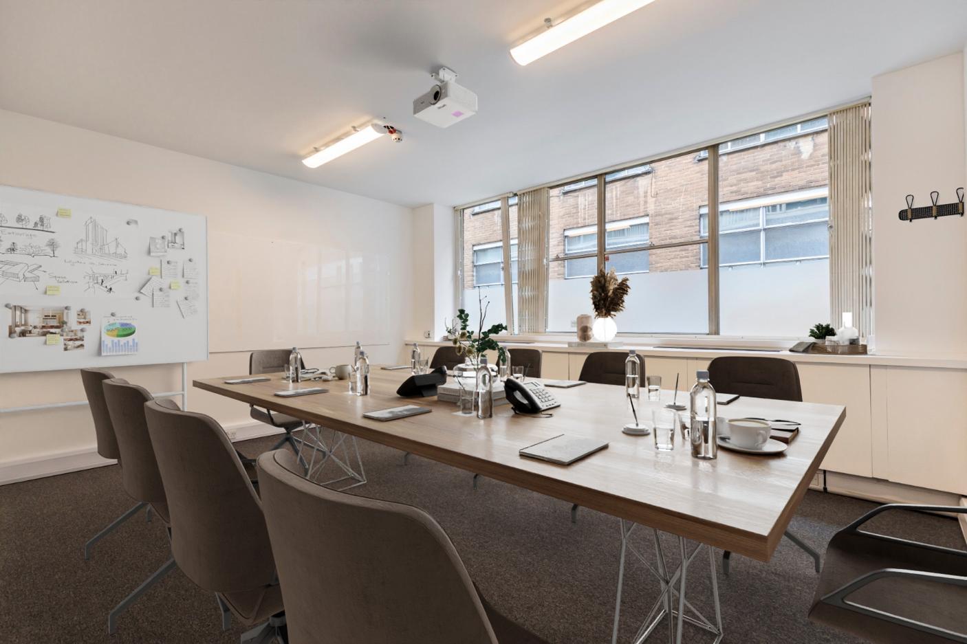 Modern meeting room with large wooden table, ideal for presentations and brainstorming.