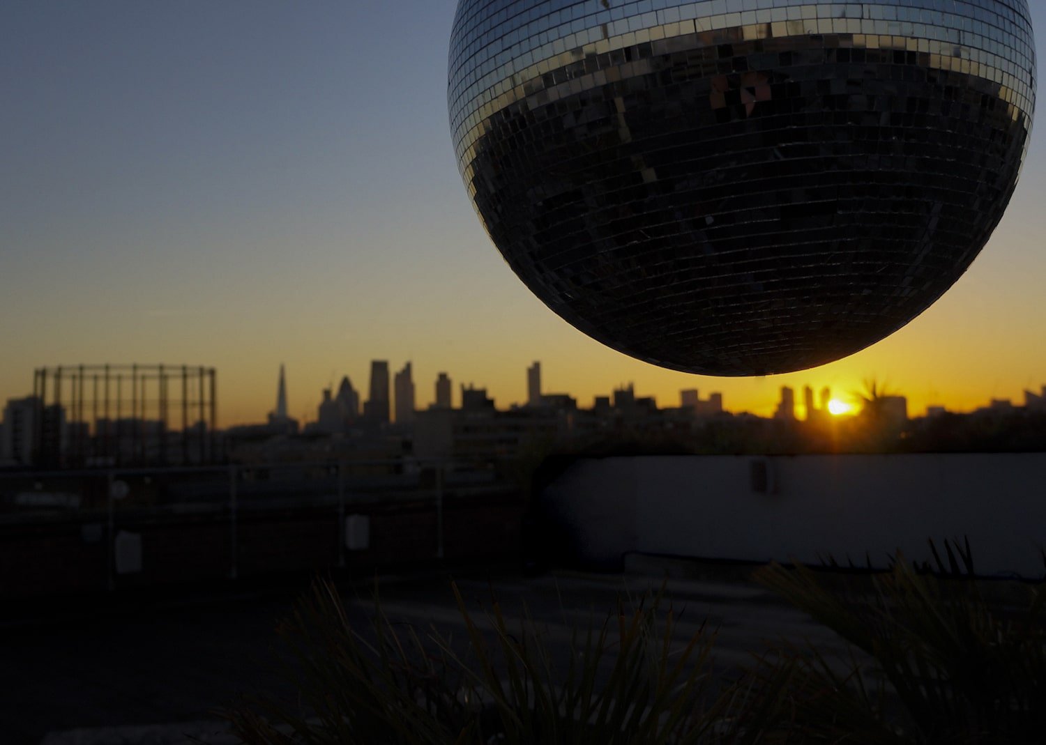 Stunning sunset at Netil360 Rooftop Bar with disco ball, ideal for events and celebrations.