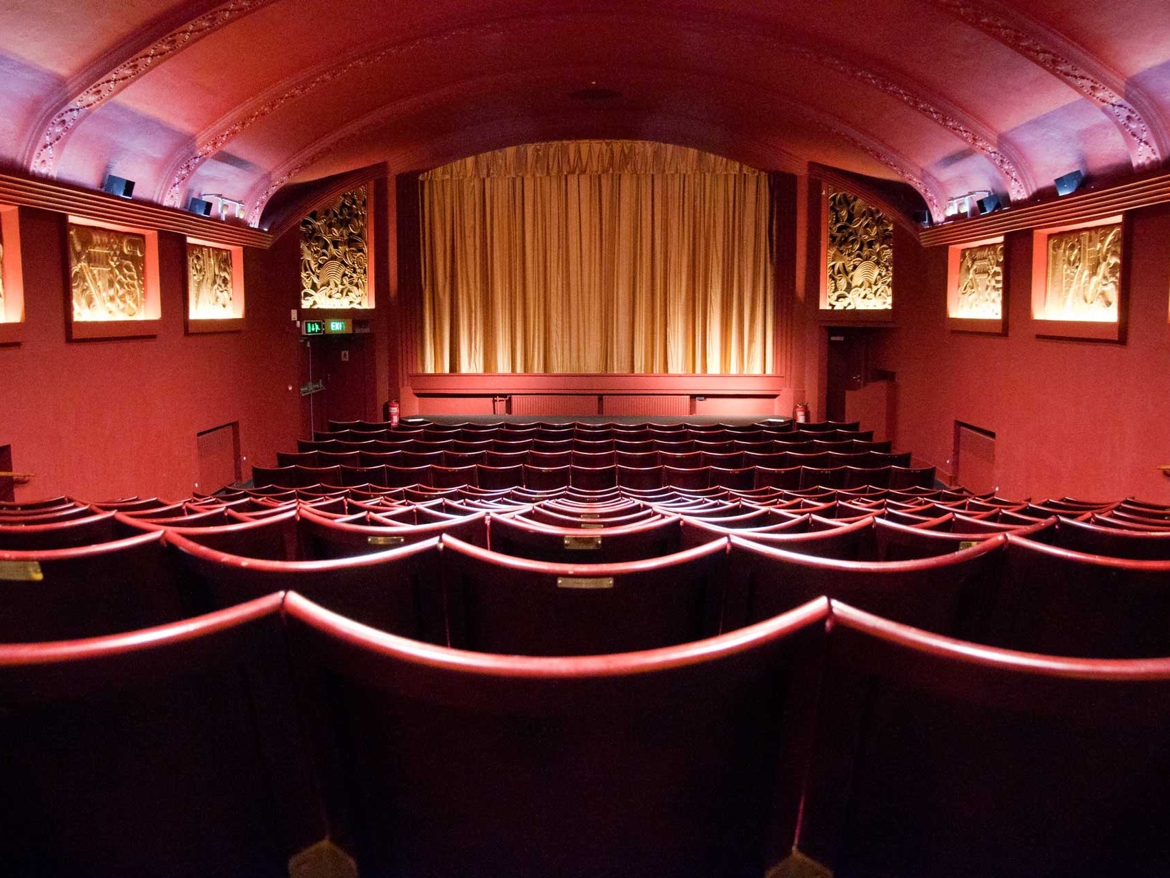 Elegant Genesis Cinema theater with rich red decor, ideal for film screenings and presentations.