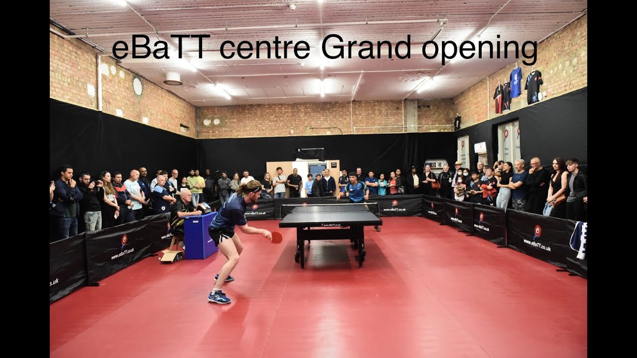 Table tennis match at eBaTT center grand opening, vibrant atmosphere and engaged spectators.