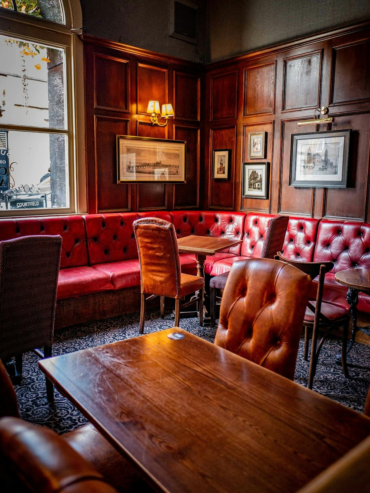Cozy pub seating area with red upholstery, ideal for networking events and meetings.