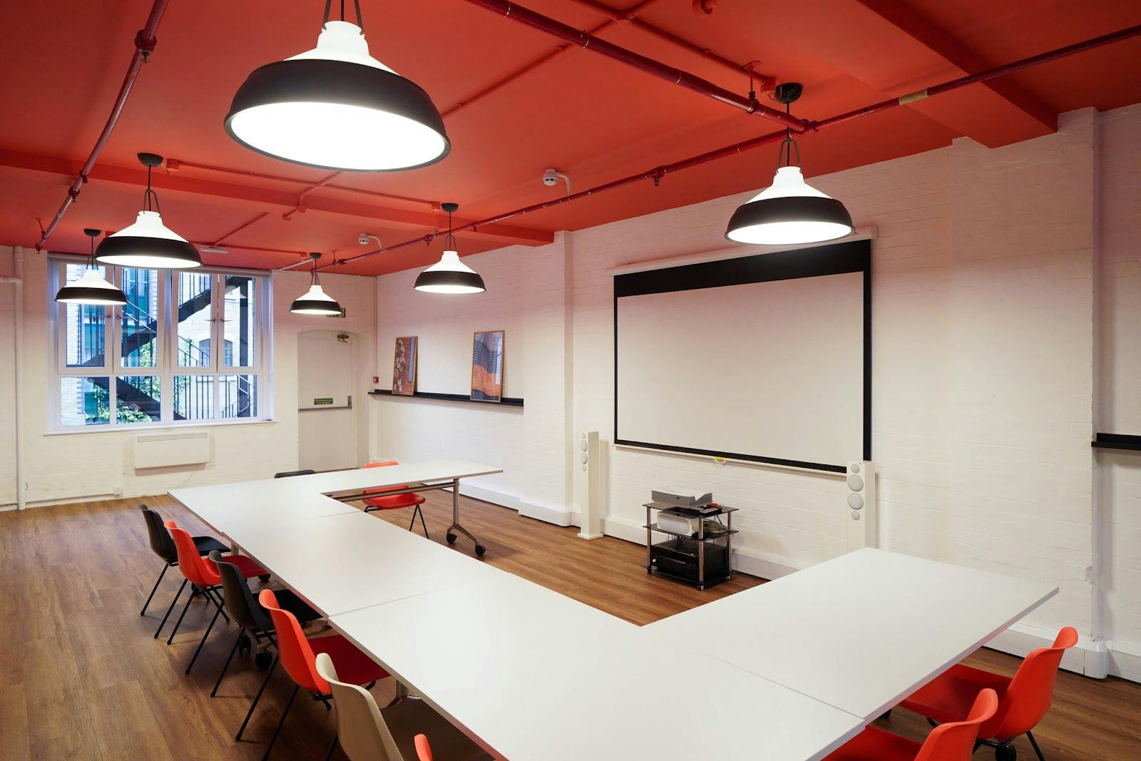 Modern meeting room in London Bridge Hive with red ceiling, ideal for workshops and events.