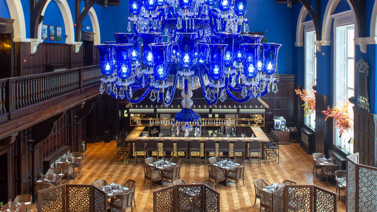 Elegant Tea Lounge at The LaLiT London with grand blue chandelier for upscale events.