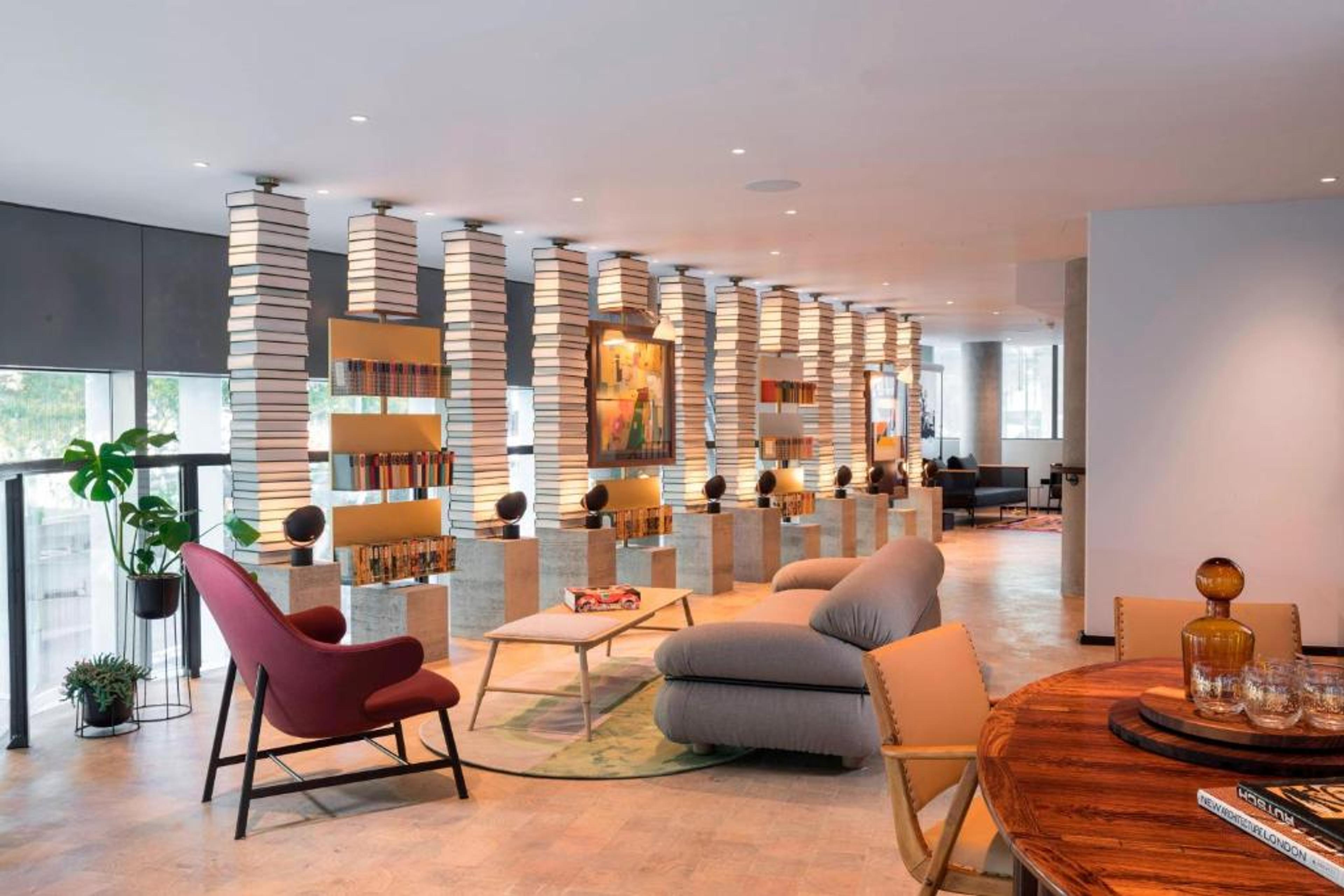 Modern meeting space at Bankside Hotel with book-lined columns for networking events.