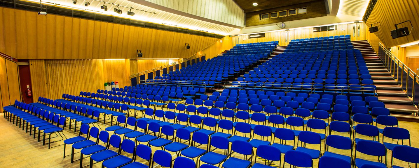 Imperial College Business School lecture theatre with blue chairs for events and presentations.