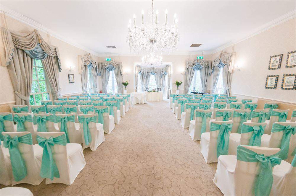 Elegant Manor House event space with turquoise sashes, perfect for weddings and gatherings.