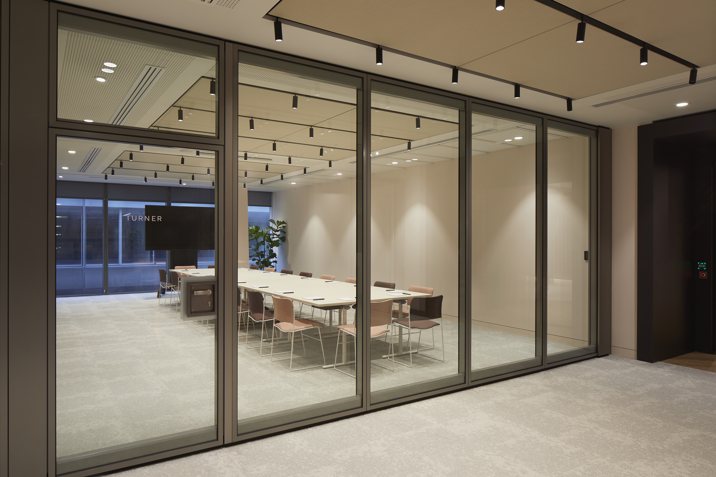 Modern conference room with glass walls, ideal for professional meetings and presentations.