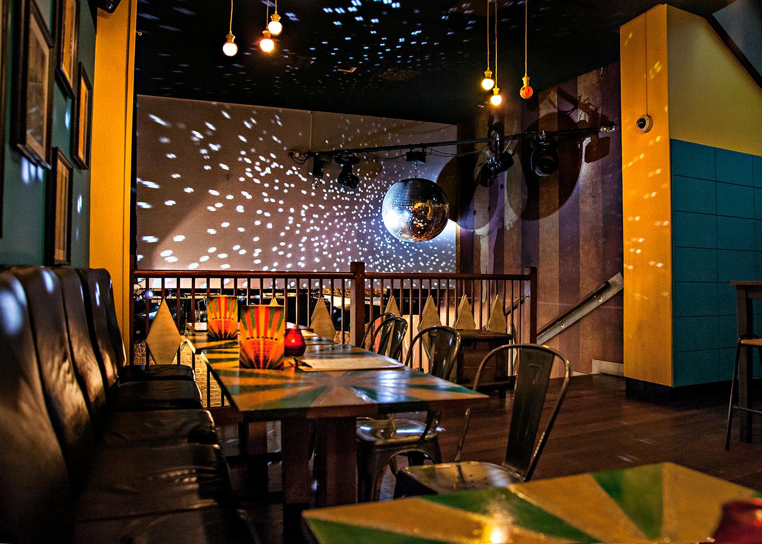 Mezzanine at Capeesh Cucina: vibrant event space with disco ball, ideal for gatherings.