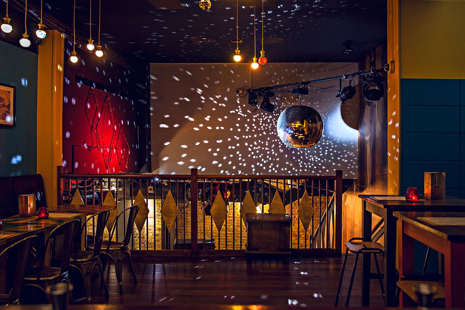 Vibrant Mezzanine at Capeesh Cucina, ideal for events with stylish decor and disco ball.