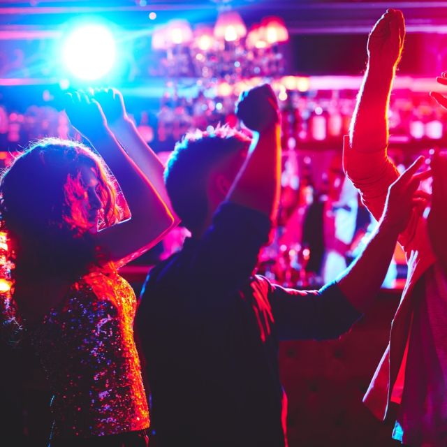 Groupon karaoke room with colorful lighting at a lively social event.