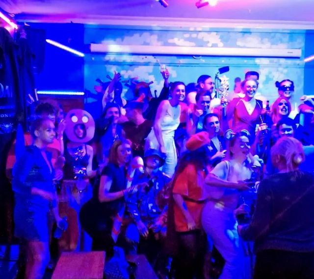 Vibrant GROUPON karaoke room with colorful lighting for fun networking events.