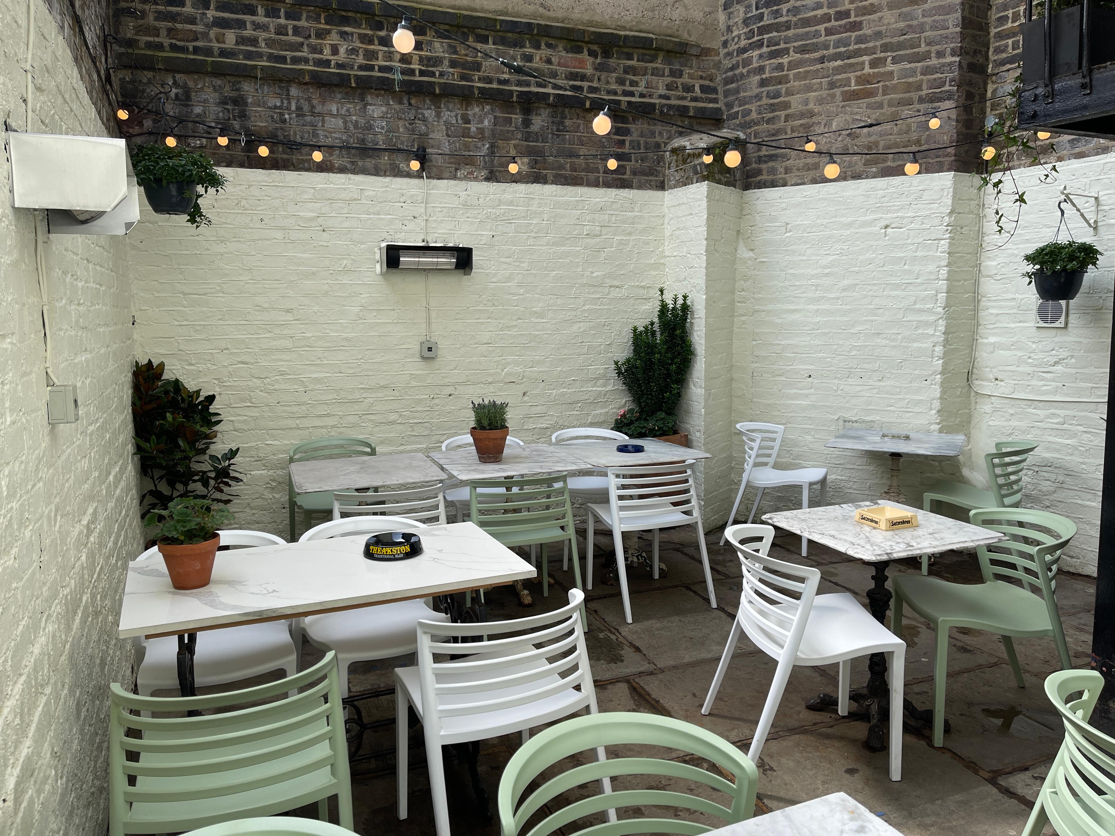 Charming outdoor meeting space with string lights at The Mall Tavern, Notting Hill.