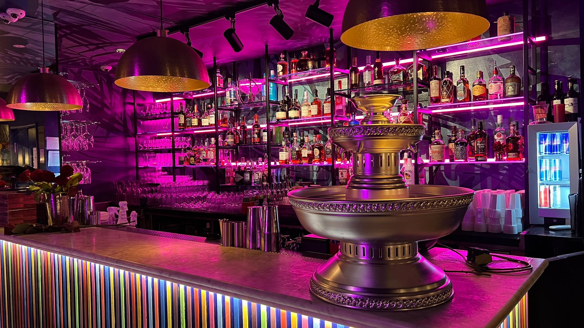 Vibrant bar at The Cottons Club with fountain, ideal for events and gatherings.