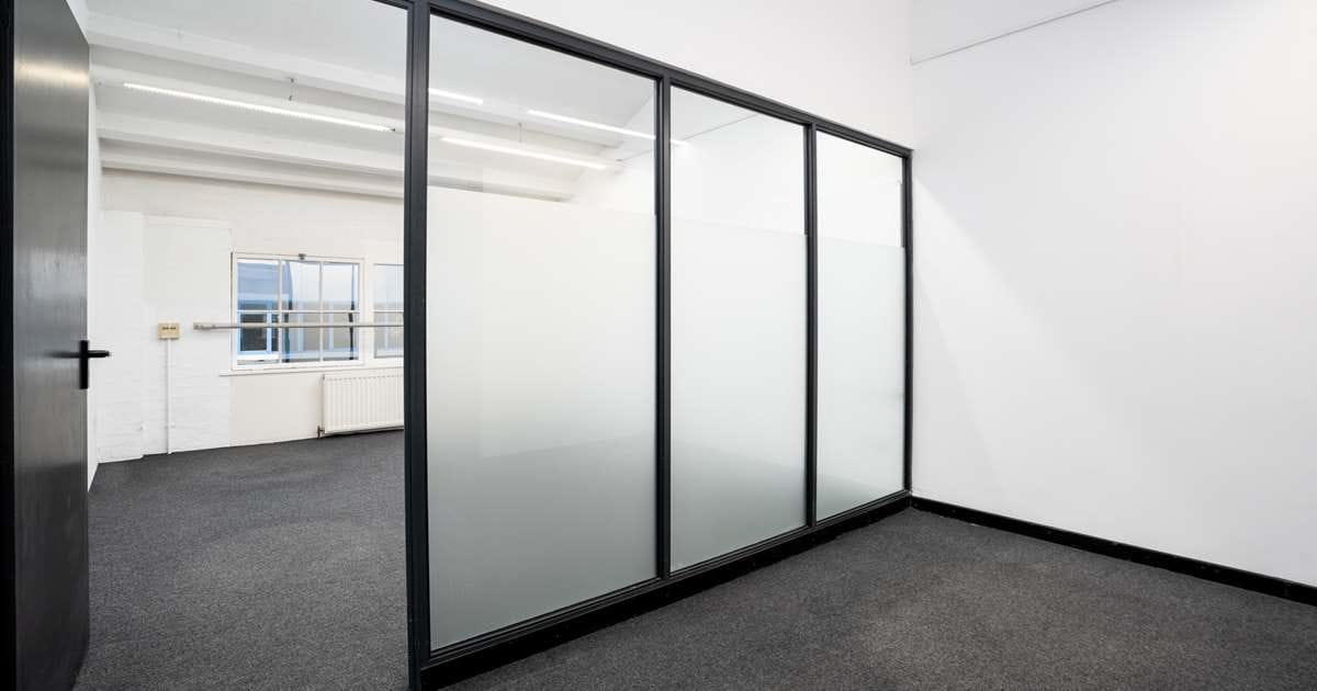 Modern meeting room with glass walls, ideal for collaboration and brainstorming sessions.