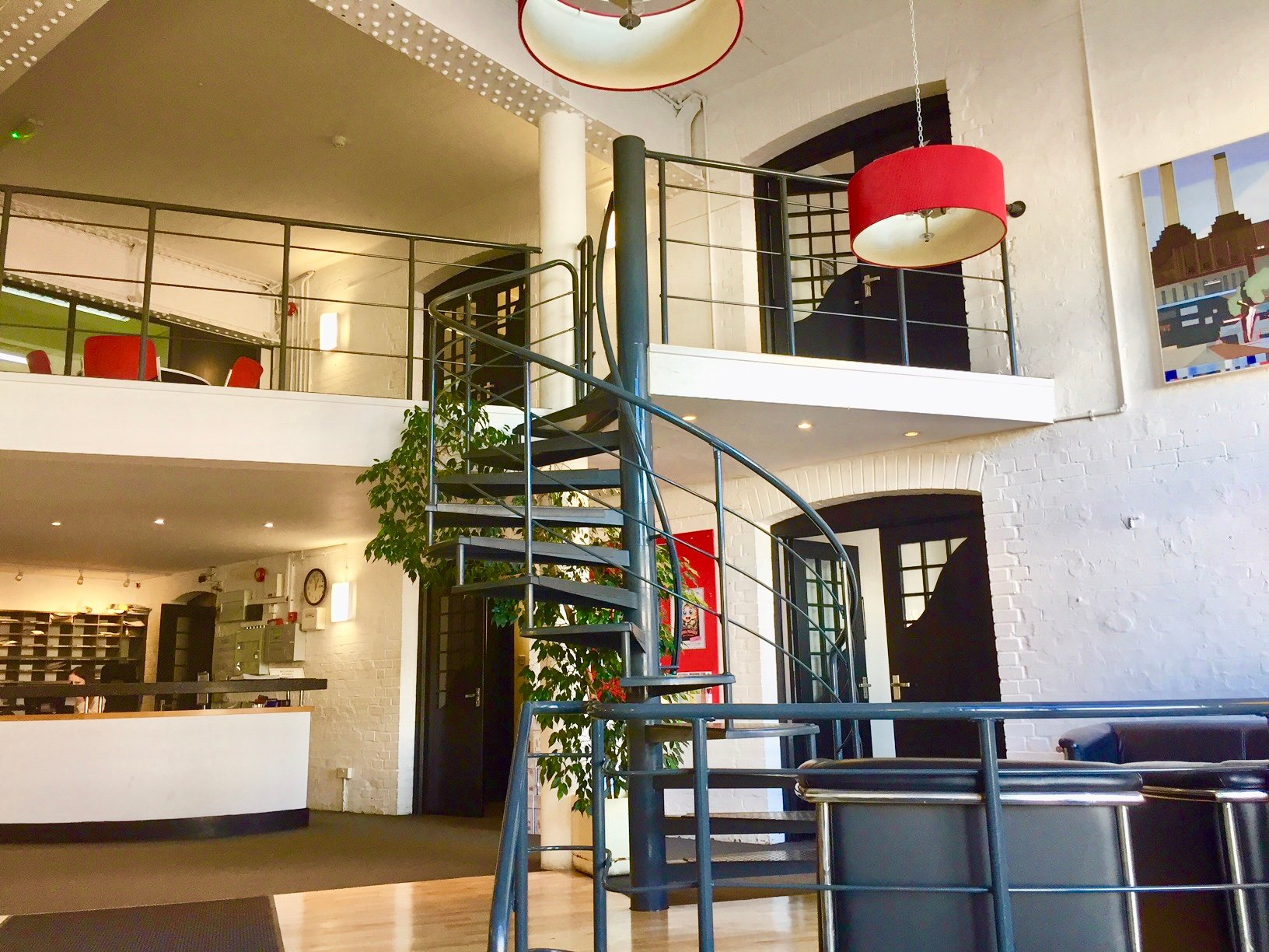 Modern open-concept venue with spiral staircase for creative meetings and workshops.