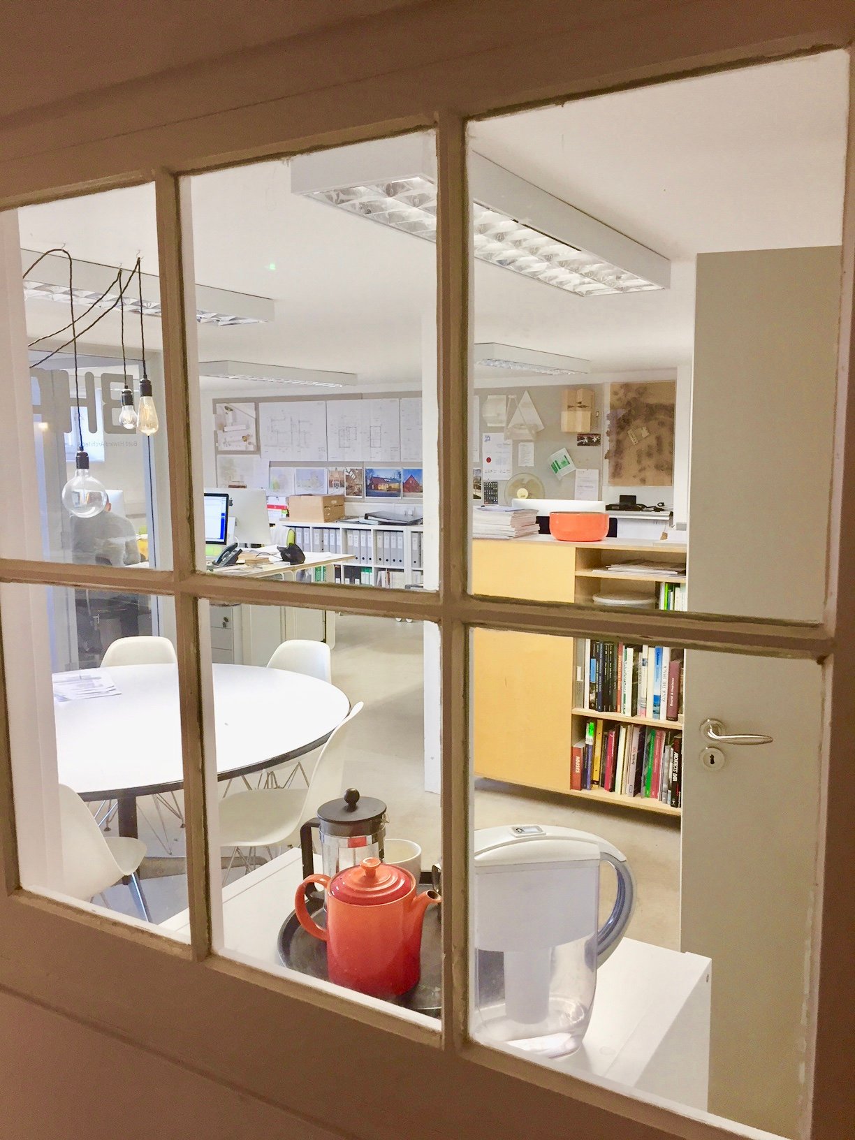 Versatile meeting room with round table in bright Busworks studio for creative events.