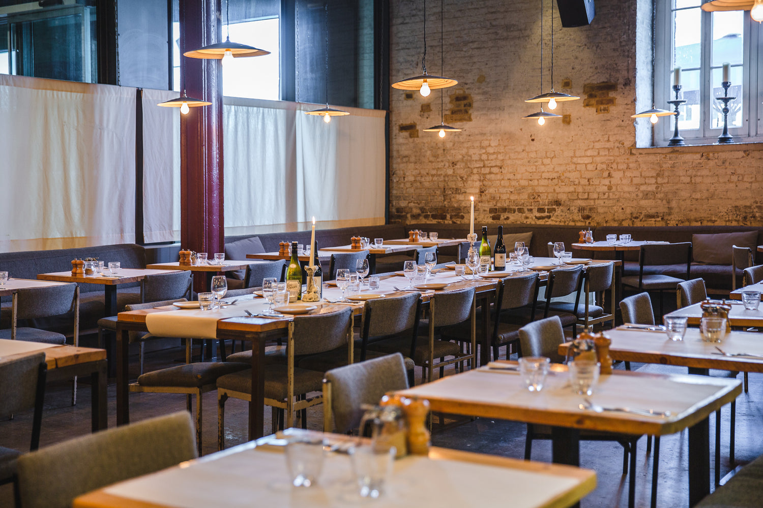 Semi-private dining area with long tables, ideal for events at Caravan Canary Wharf.