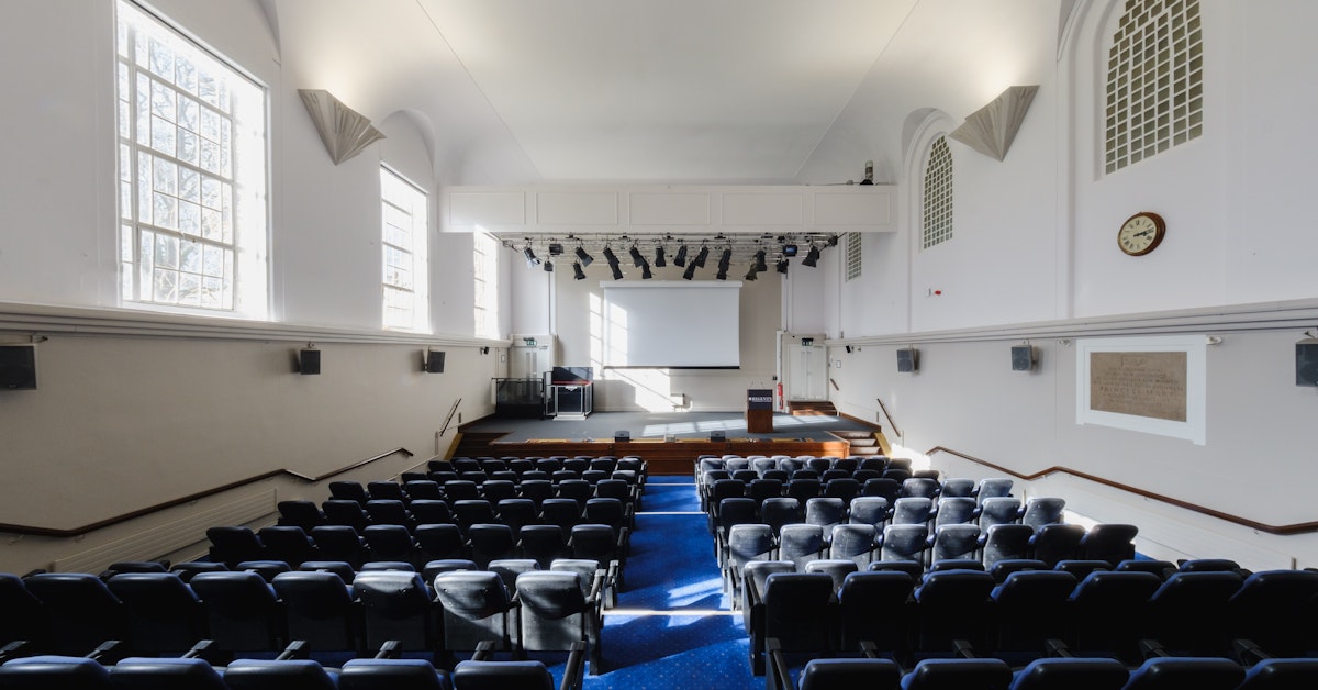 Tuke Hall conference room with seating and stage, perfect for presentations and events.