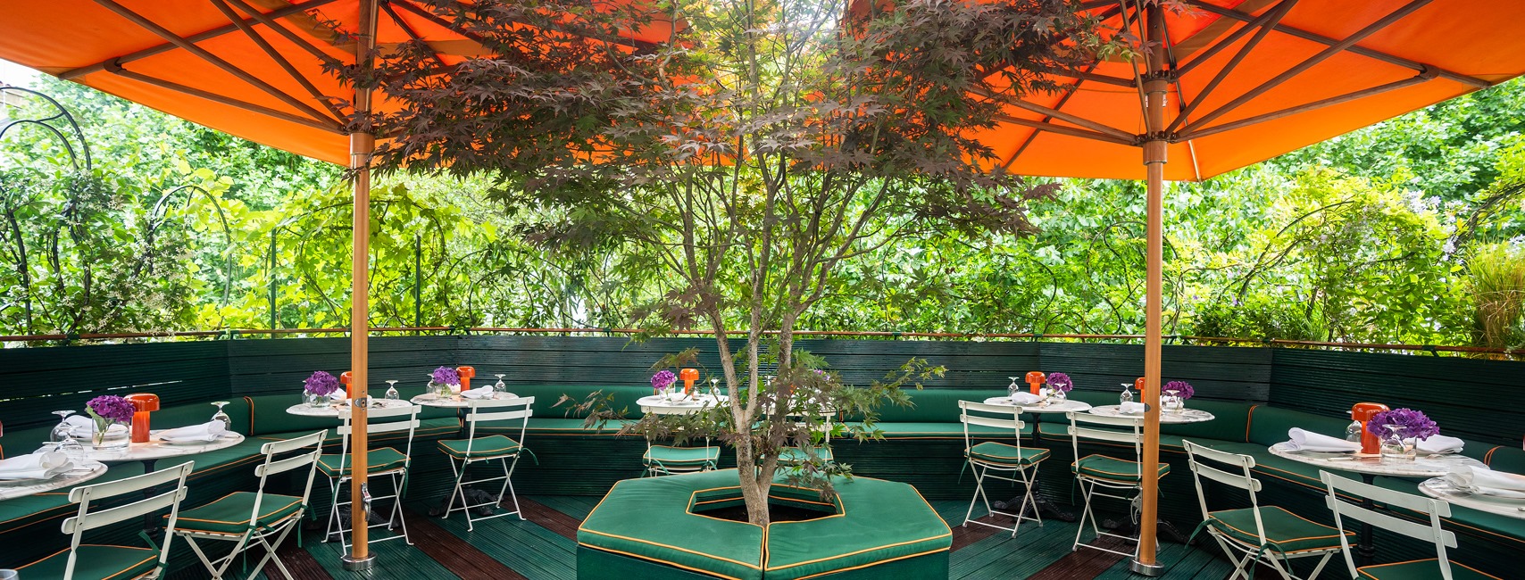Roof Terrace at Casa Cruz London with stylish tables under orange umbrellas for outdoor events.