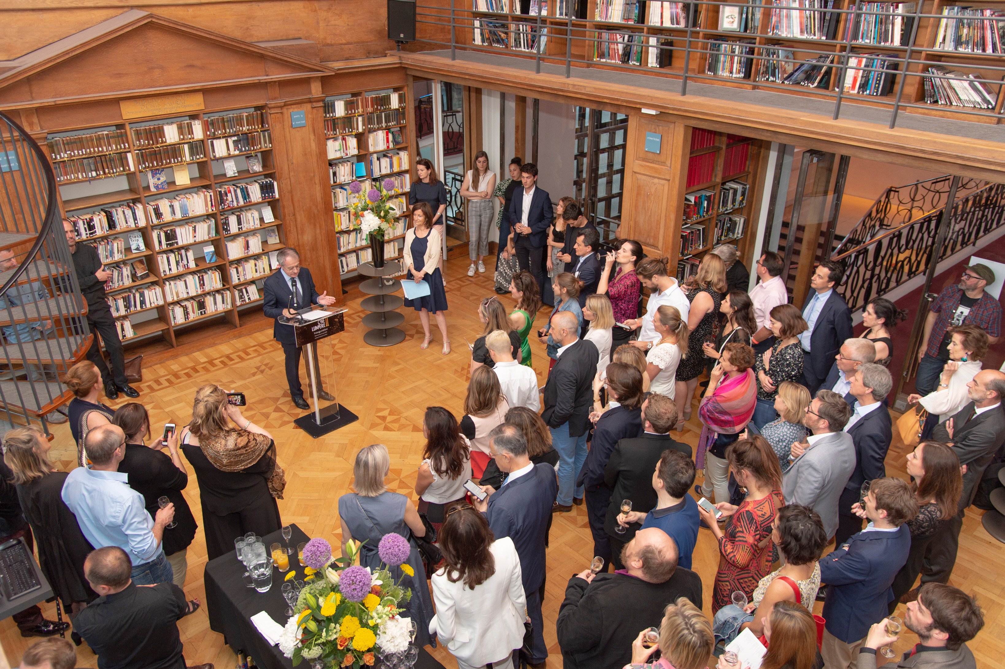 Ciné Lumière event with engaging speaker in stylish library setting, perfect for networking.