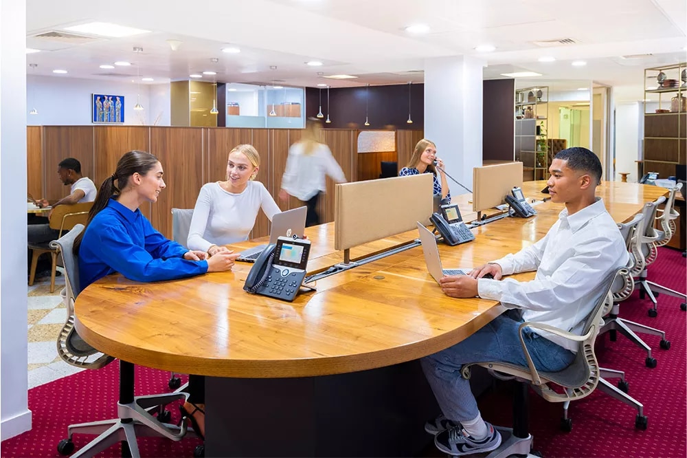 Modern co-working meeting room with round table for collaboration at Servcorp Canary Wharf.