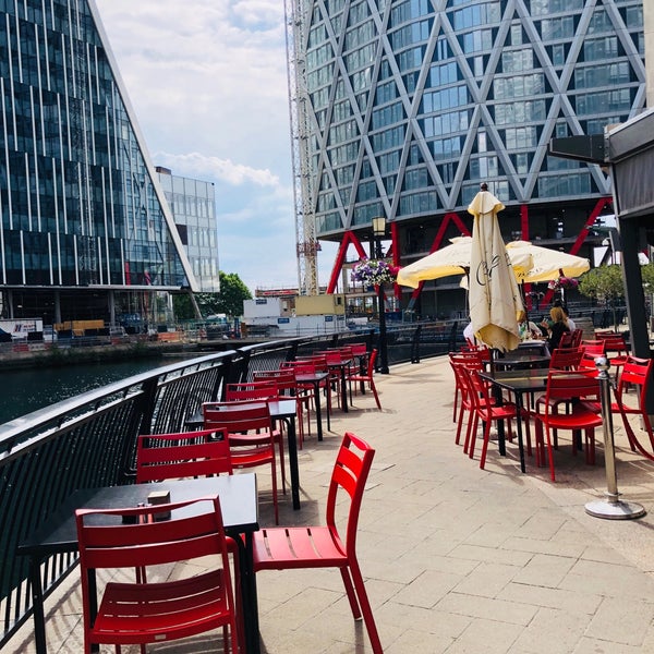 Outdoor terrace with red chairs, ideal for summer networking events by the waterfront.