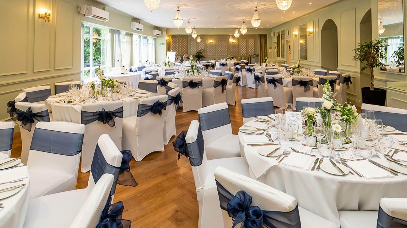 Elegant event space at The Clarendon Hotel with navy blue chair sashes, perfect for weddings.
