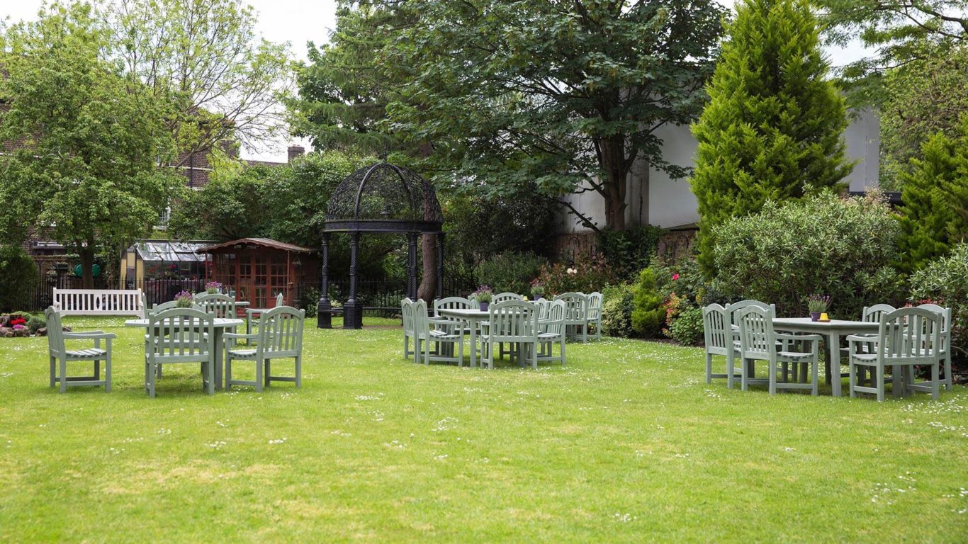 Gardens at The Clarendon Hotel with rustic tables, ideal for summer events and meetings.