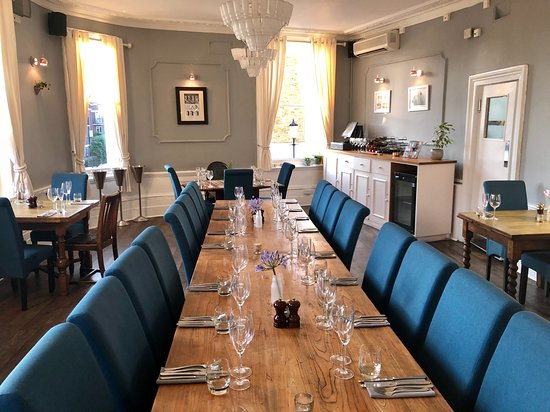 Private dining room with wooden table and blue chairs, ideal for corporate events and gatherings.