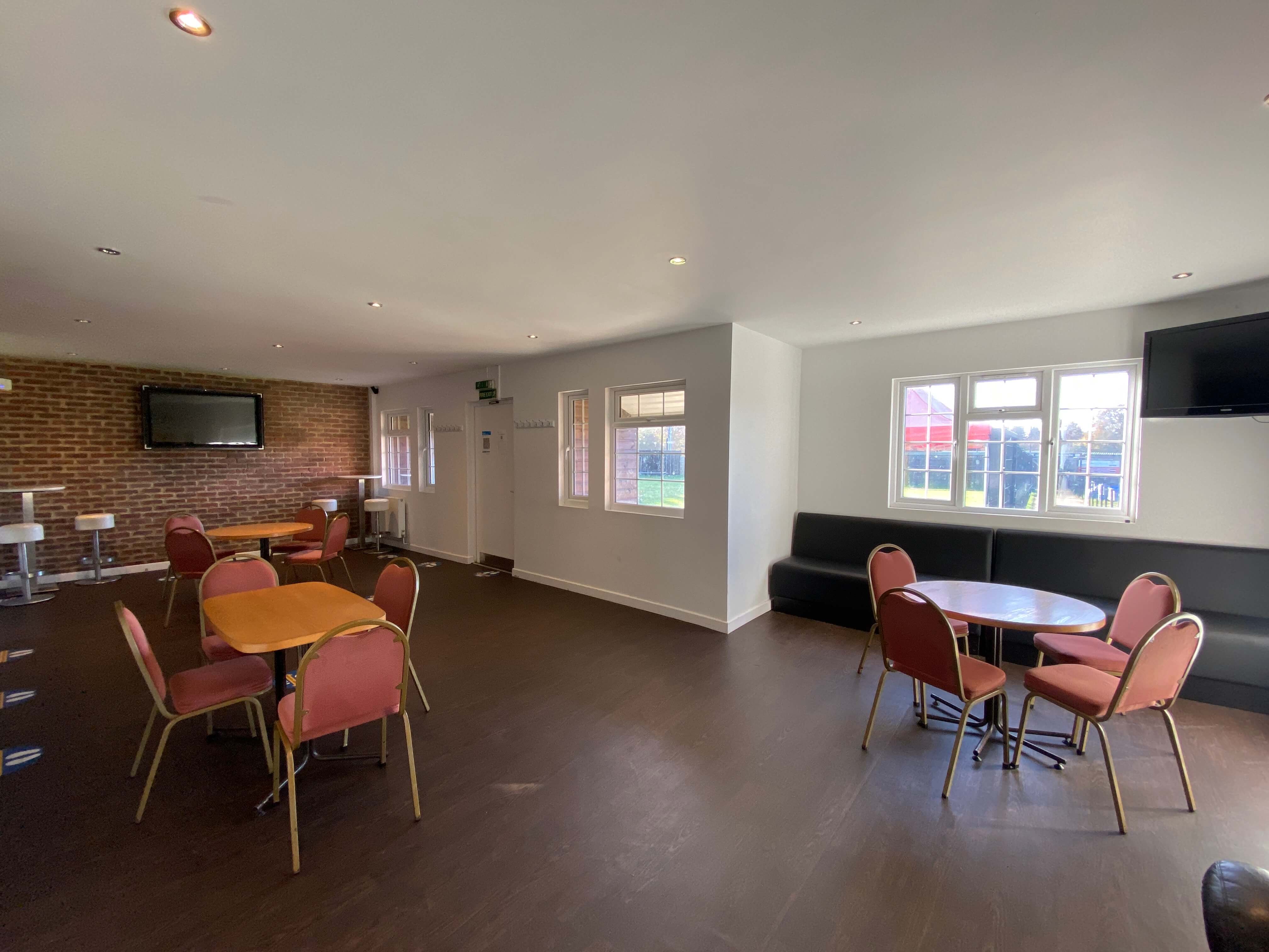 Versatile event space at The Pavilion, featuring round tables and natural light.