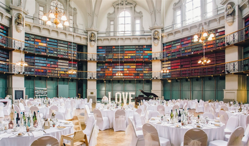 Elegant wedding venue with round tables and a romantic "LOVE" sign in Queen Mary.