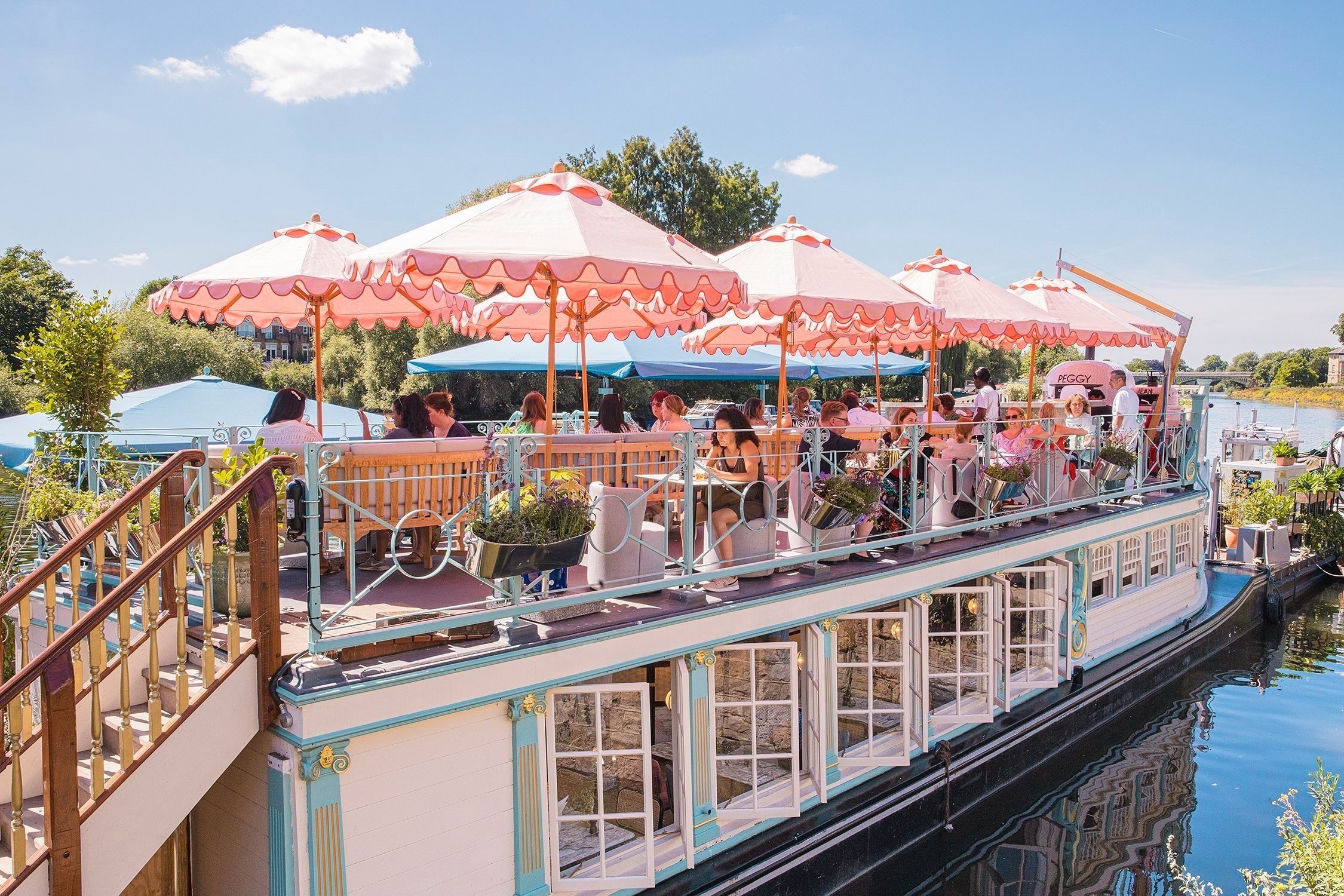 Vibrant outdoor restaurant on a boat with colorful umbrellas for unique events.